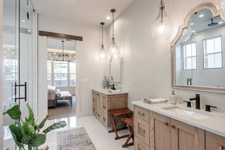 The room is a bathroom with two sinks and three pendant lights hanging from the ceiling.