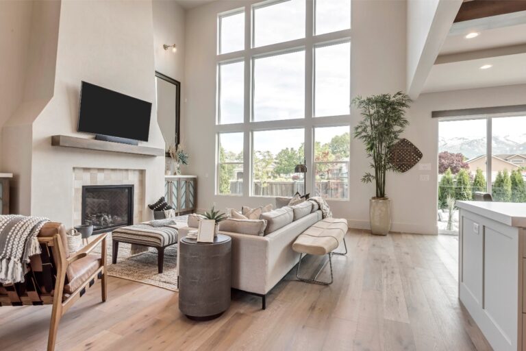 A white room with a TV and fireplace is shown through a window.