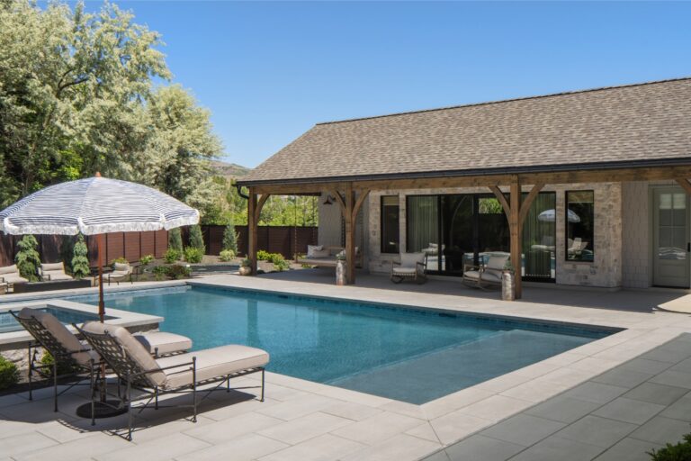 A white-washed photo of a pool and house with an umbrella.