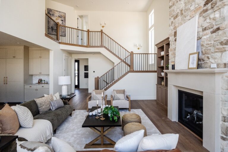A room with a fireplace and staircase has white walls and brown furniture.