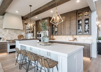 The image is a photo of an indoor kitchen with white cabinets and brown countertops.