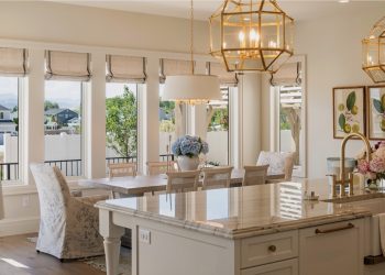 The room is white and has a dining table with chairs near it.