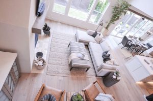 The room is a modern space with white walls and furniture featuring natural materials like wood and stone.