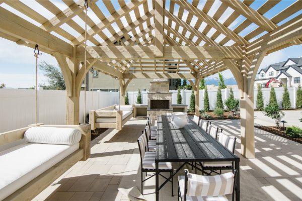 A white-washed photo of a wooden pergola with tables and chairs underneath it.